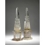 A pair of rock crystal obelisks, with tapering stems on stepped plinths, each with a printed