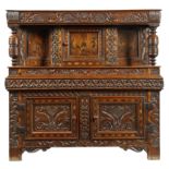 A Welsh oak and marquetry press cupboard, inlaid with parquetry banding, the frieze naively carved