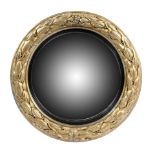 A Regency giltwood convex wall mirror, the circular plate within an ebonised reeded slip and a