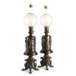 A pair of late 19th century French bronze table lamps, each with a globe shade above a body cast