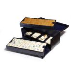 A bone and bamboo mahjong set, contained in a blue leather case with two trays of tiles above four