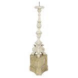 An Italian carved and painted wood altar candlestick, with a leaf carved baluster stem, on a triform