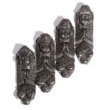 A set of four 17th century carved oak corbels, each with a winged angel mask above hanging fruit,