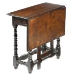 An early 18th century oak gateleg table, the single drop-leaf top on baluster ring and bobbin turned