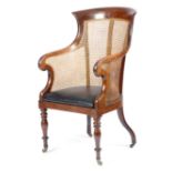 An early Victorian mahogany bergere armchair, with a drop-in seat with later leather upholstery,