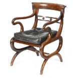 A Regency mahogany open armchair, the curved scroll reeded back above a rondel decorated