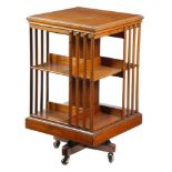 An Edwardian walnut revolving bookcase, on ceramic castors, 86cm high, 49cm square. Provenance: