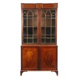 A Regency mahogany and satinwood bookcase cabinet, inlaid with stringing, the detachable cornice