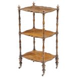 λ An early Victorian rosewood serpentine three-tier whatnot, with turned twin baluster supports,