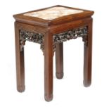 A Chinese hardwood low stand, the top inset with a marble panel, the pierced and carved frieze