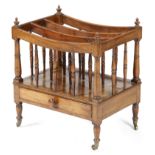 A Regency mahogany Canterbury, with three dipped divisions, supported by ring turned spindles, above