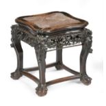 A late 19th century Chinese hardwood low stand, the top inset with a marble panel, above a carved