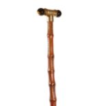 A George V swagger stick, the gilt metal handle with twin tiger's eyes and inscribed 'C. D. XMAS