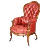 A mid-19th century walnut armchair, later button upholstered with studded red leather, with a