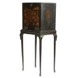 A black japanned cabinet on stand, decorated in gilt with chinoiserie scenes with figures and