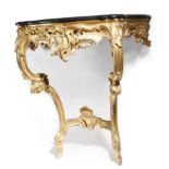 A Louis XV giltwood console table, the later black marble top with a serpentine edge, the foliate