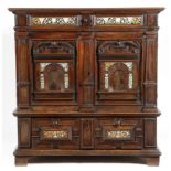 A 17th century oak enclosed chest, with a panelled frieze drawer, decorated with ebony panels,