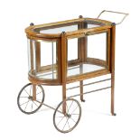 A novelty oak display cabinet in the form of a trolley, with brass mounts and glass panels with a