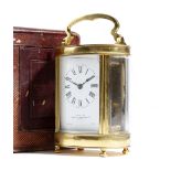 A French gilt brass oval carriage clock, with a platform lever escapement, the enamel rectangular