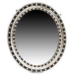 An Irish ebonised and silvered wood oval wall mirror, the moulded frame decorated with faceted cut-