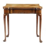 A George II red walnut card table, the hinged top with eared corners revealing a baize lined