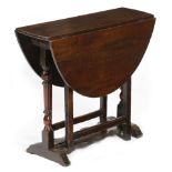 A small early 18th century oak gateleg table, the oval drop-leaf top on cup and baluster turned