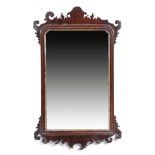 A George II red walnut fret-frame mirror, the original bevelled plate with cusped top corners, in