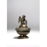 An early 19th century French bronze Grand Tour inkwell, the lid modelled with Cupid seated holding a
