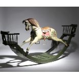 An Edwardian country house carved and painted dapple grey see-saw rocking horse in the manner of G &