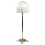 A brass Corinthian column standard lamp, with a reeded stem, on a stepped plinth and lion's paw