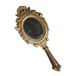 An Italian giltwood hand mirror, the oval plate within a leaf, husk and shell carved frame, 19th