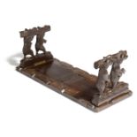 A Black Forest carved wood bookslide, the hinged folding ends each carved with a pair of