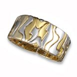 A yellow and white gold bangle, of abstract design, 5.3cm inner diameter, 108g