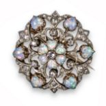 An Edwardian opal and diamond circular brooch pendant, centred with a circular-cut diamond within