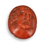 A carved coral cameo depicting Bacchus, c1800, bearded and wearing fruiting vines, and with a