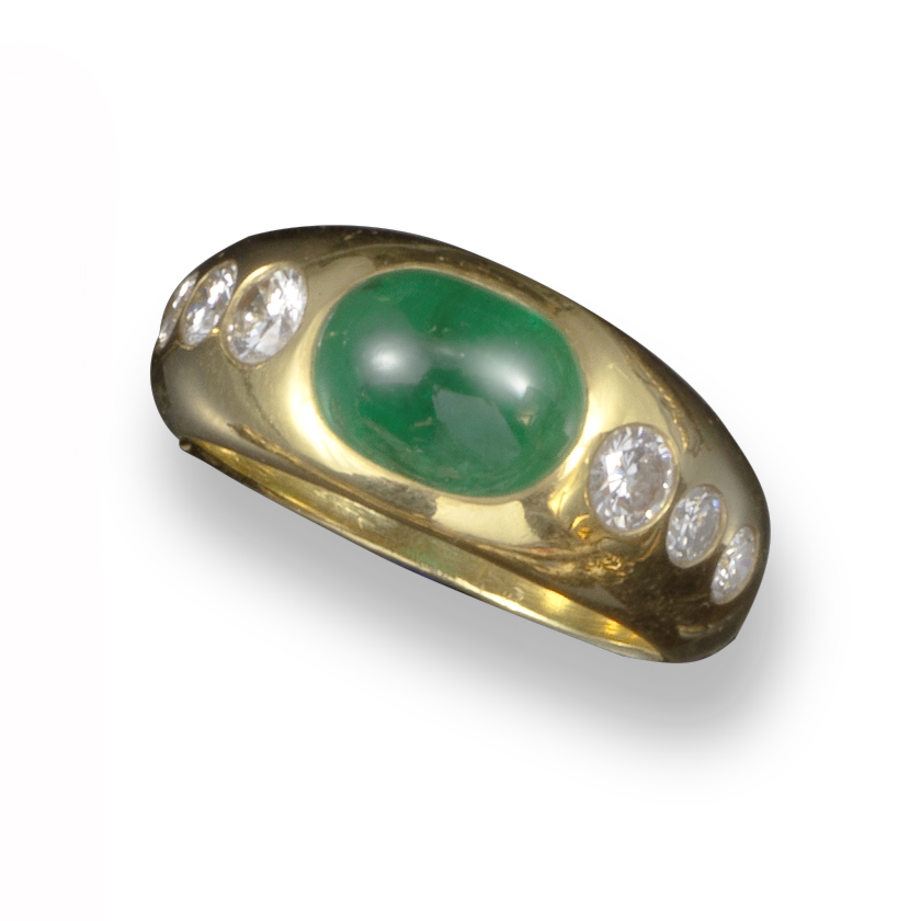An emerald and diamond gypsy ring, set with an emerald cabochon and three graduated round