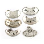 A collection of six antique silver wine labels, kidney shape, various dates and makers,