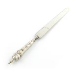 An electroplated novelty pencil and paper knife, unmarked, the handle with a pencil, tapering blade,