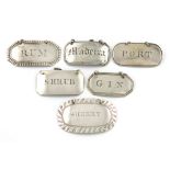 A collection of five Scottish silver wine labels, various designs, dates and makers incised 'SHRUB',