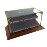 A S. Mordan and Co. display case, rectangular glass body, on a raised tapering wooden rectangular