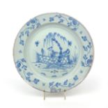 A large delftware charger c.1760, painted in blue with a Chinese figure standing behind an