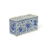 A large Delft flowerbrick 18th century, the rectangular form painted in blue with a dense floral