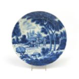 A large London delftware charger c.1720, painted in blue with travellers at rest beneath tall