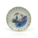 A Brislington delftware plate c.1710-20, painted in polychrome enamels with a hut beneath a pine