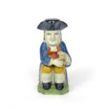 A Pratt ware Toby jug and cover c.1790-1800, seated and resting a foaming jug of ale on his left