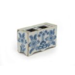 A delftware flower brick c.1750, the rectangular form painted in blue with sprays of Oriental