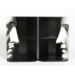 A pair of Fornasetti hanging corner cupboards, each with printed face in profile, in black and