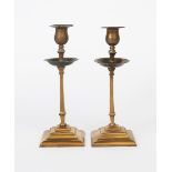 A pair of W.A.S. Benson patinated copper and brass candlesticks, model no.2A tapering square