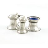 By Omar Ramsden, a three-piece Arts and Crafts silver condiment set, London 1920 and 1922, also