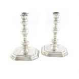 A pair of Queen Anne cast silver candlesticks, by David Willaume I, London 1704, octagonal